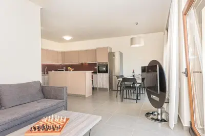 a living room with a couch and chessboard on a table at SUNRISE Spacious Apartment With 3 Bedrooms & 3 Bathrooms -Near to Chania in Kolymvari