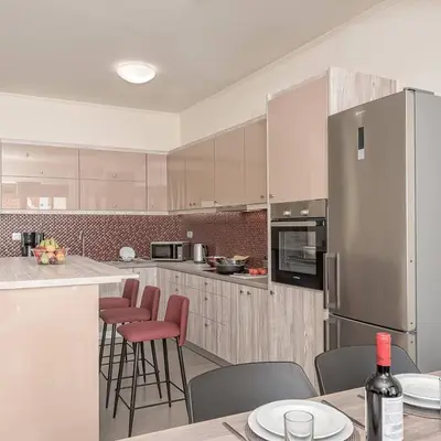 a kitchen with white cabinets and red bar stools at SUNRISE Spacious Apartment With 3 Bedrooms & 3 Bathrooms -Near to Chania in Kolymvari