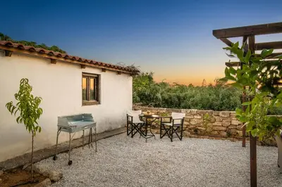 a patio with a table and chairs next to a building at Beit Petra in Daratso