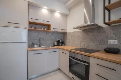 a kitchen with white cabinets and wooden counter tops at Mezoneta 