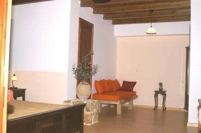 a living room with an orange couch in a room at Sarris House in Xirokámbion
