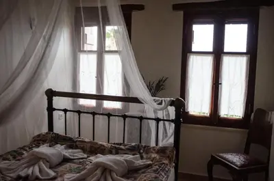 a bedroom with a bed and two windows at Sarris House in Xirokámbion