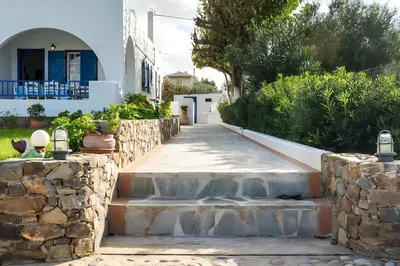 a walkway leading to a house with a stone wall at Blue Beach House in Kissamos