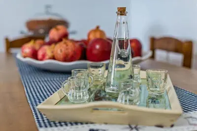a table with a tray of glasses and a plate of apples at Blue Beach House in Kissamos