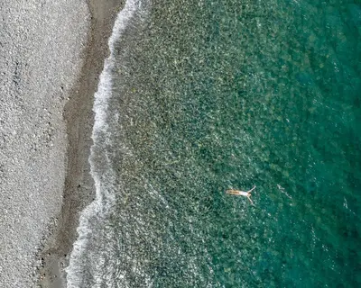 an overhead view of a person swimming in the ocean at Athina Luxury Villa, with Pool & Walk to the Beach, By ThinkVilla in Chania Town