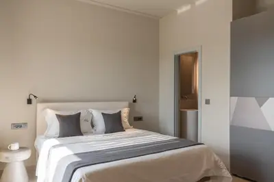 a white bedroom with a large white bed with pillows at Athina Luxury Villa, with Pool & Walk to the Beach, By ThinkVilla in Chania Town