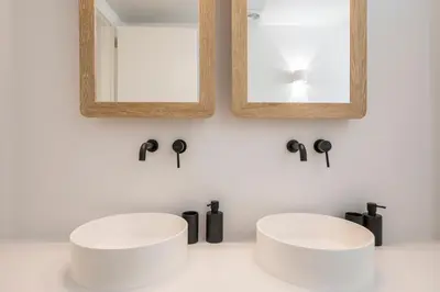 a bathroom with two white sinks and a mirror at Villa Everlong in Vamos