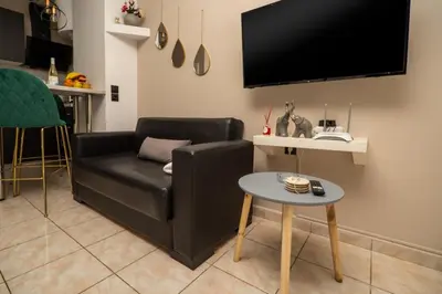 a living room with a black couch and a table at welcome Dream home in Chania Town