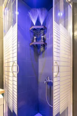 a blue bathroom with a shower with blue tiles at welcome Dream home in Chania Town