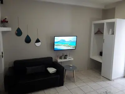 a living room with a black couch and a flat screen tv at welcome Dream home in Chania Town