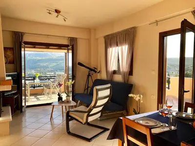a living room with a table and chairs with a view at Zafeiria's Suite in Vamos