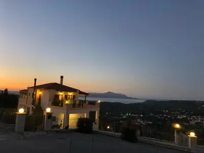 a house with a view of the ocean at night at Zafeiria's Suite in Vamos
