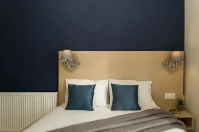 a bedroom with a bed with two blue pillows at Majestic Villa in Chania Town