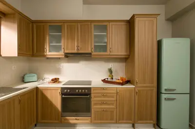 a kitchen with wooden cabinets and a refrigerator at Majestic Villa in Chania Town