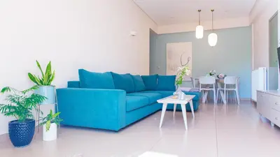 a living room with a blue couch and a table at Happiness Luxury Home in Palaiochóra