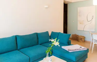 a blue couch in a living room with a table at Happiness Luxury Home in Palaiochóra
