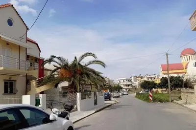 a car parked on the side of a street with a palm tree at Roof-Garden Apartment in Chania Town