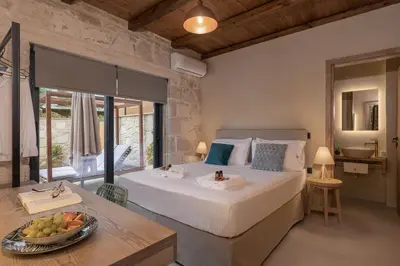 a bedroom with a bed and a table with a bowl of fruit at Villa Magnolia in Ayiá