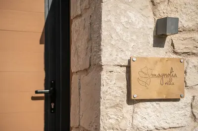 a sign on the side of a building with a door at Villa Magnolia in Ayiá