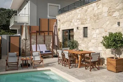 a patio with a table and chairs next to a pool at Villa Magnolia in Ayiá