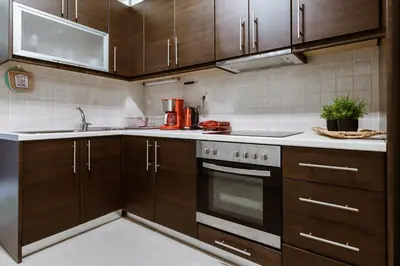 a kitchen with wooden cabinets and a stove top oven at Lazaretta apartment in Chania Town