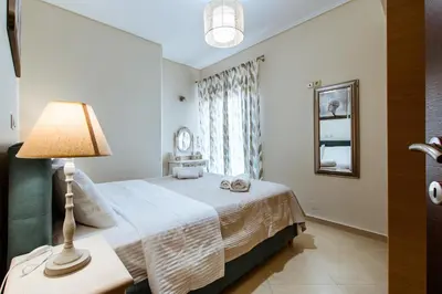 a bedroom with a bed with a lamp and a window at Lazaretta apartment in Chania Town