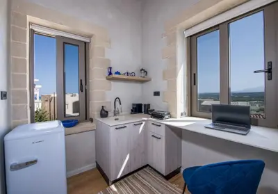 a kitchen with a laptop on a counter with windows at Casa di Grimpili in Kolymvari