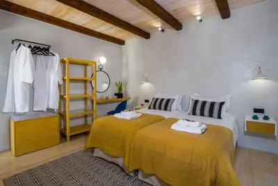 a bedroom with a large bed and a yellow blanket at Casa di Grimpili in Kolymvari