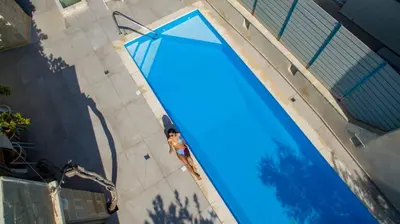 a woman standing next to a large swimming pool at Casa di Grimpili in Kolymvari