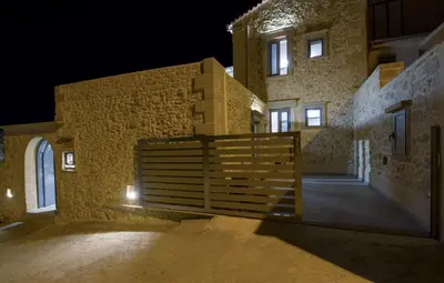 a building with a wooden gate in front of it at night at Casa di Grimpili in Kolymvari