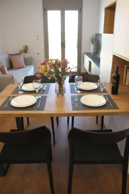 a dining room table with plates and wine glasses at New Cozy Chic Apt-Ryfete Luxury Living in Kalathas