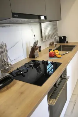 a kitchen counter with a stove and a sink at New Cozy Chic Apt-Ryfete Luxury Living in Kalathas