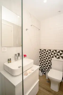 a white bathroom with a sink and a toilet at Fragios Beach House in Chania Town