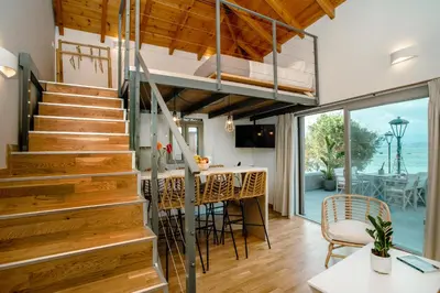a staircase in a house with a kitchen and dining room at Fragios Beach House in Chania Town