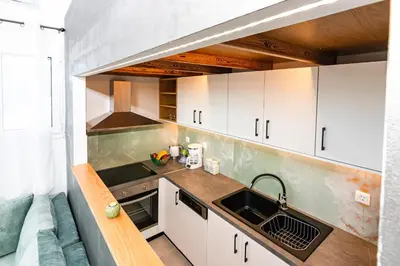 a small kitchen with white cabinets and a sink at Rikanthos Stone Sea View Apartment Ι in Falelianá