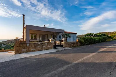 a small house on the side of a road at Rikanthos Stone Sea View Apartment Ι in Falelianá