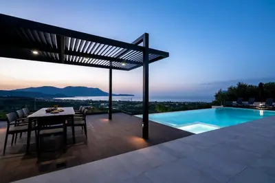 a patio with a table and a swimming pool at Villas Phos and Kallos in Kissamos