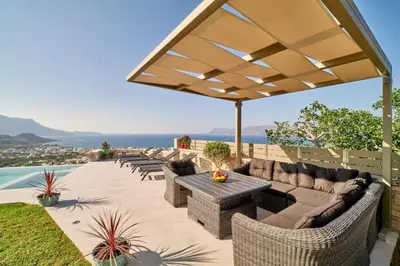 a patio with couches and a table and chairs at Luxury Villa Argi infinity private pool in Kissamos