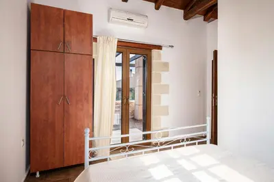 a bedroom with a bed and a large window at Villa Eleonas in Vamos
