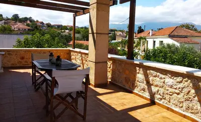 a table and chairs on the balcony of a house at Villa Eleonas in Vamos