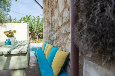 a patio with blue and yellow pillows and a table at Villa Eleonas in Vamos