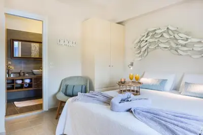 a bedroom with a bed with a blue blanket on it at VILLA AMANTELLA in Stavros