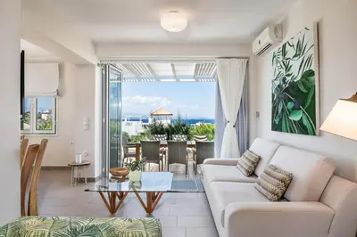 a living room with a couch and a glass table at VILLA AMANTELLA in Stavros