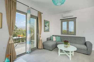 a living room with a couch and a table at SEA BREEZE APARTMENTS in Kolymvari