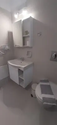 a white bathroom with a sink and a toilet at Agia Roumeli APARTMENT in Agia Roumeli