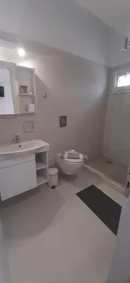 a white bathroom with a toilet and a sink at Agia Roumeli APARTMENT in Agia Roumeli
