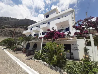 a white building with flowers on the side of it at Agia Roumeli APARTMENT in Agia Roumeli