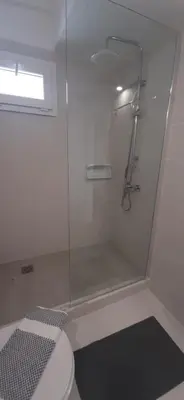 a bathroom with a glass shower with a toilet at Agia Roumeli APARTMENT in Agia Roumeli
