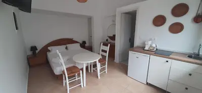 a kitchen with a white table and chairs in a room at Agia Roumeli APARTMENT in Agia Roumeli