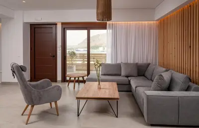 a living room with a couch and a table and chairs at Thyme Sea View Apartments by 8essentially in Souda